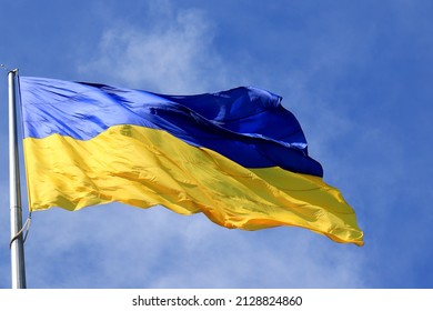 Flag of Ukraine flutters in blue sky. Large yellow  blue Ukrainian national state flag, city Kyiv Ukraine - Shutterstock ID 2128824860