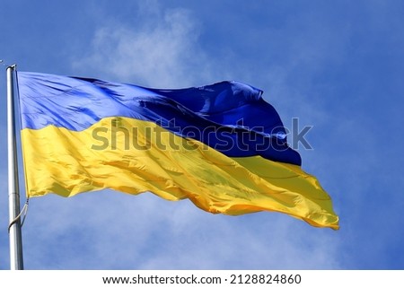 Flag of Ukraine flutters in blue sky. Large yellow  blue Ukrainian national state flag, city Kyiv Ukraine