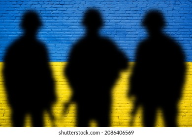 Flag Of Ukraine Painted On A Brick Wall With Soldiers. Relationship Between Ukraine And Russia