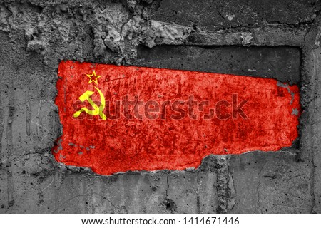 The flag of Union of Soviet Socialist Republics on a dirty wooden surface, built into a concrete base, with scuffs and scratches. Loss or destruction conception.