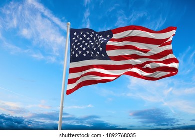 Flag of United States of America being waved in the breeze against a sunset sky.. US flag