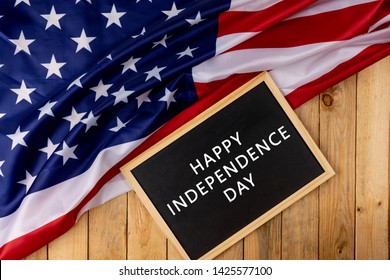 Flag of the United States of America with chalkboard on wooden background. USA holiday of Veterans, Memorial, Independence and Labor Day. - Shutterstock ID 1425577100