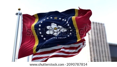 the flag of the US state of Mississippi waving in the wind with the American flag blurred in the background. Mississippi was admitted to the Union on December 10, 1817 as 20th state