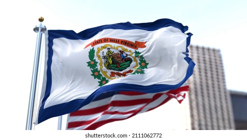 the flag of the US state of West Virginia waving in the wind with the American flag blurred in the background. West Virginia was admitted to the Union on June 20, 1863 as 35th state - Shutterstock ID 2111062772