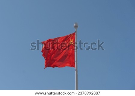 The flag of the USSR against the sky flutters in the wind