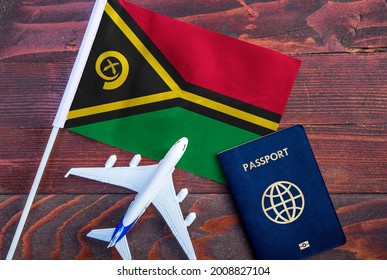 Flag Of Vanuatu With Passport And Toy Airplane On Wooden Background. Flight Travel Concept 