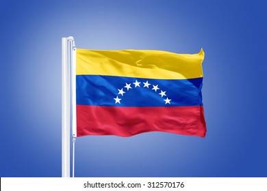 Flag Of Venezuela Flying Against A Blue Sky.