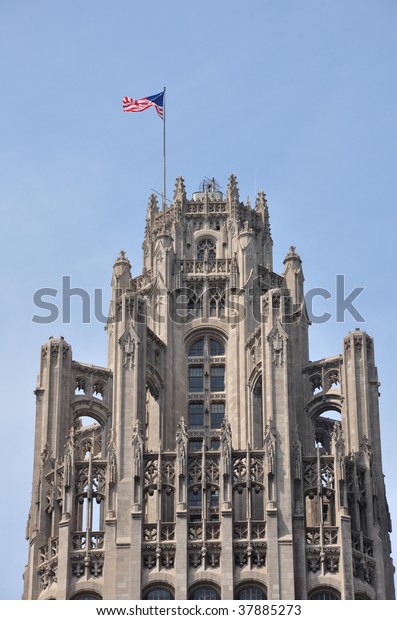Flag\
waving atop the Tribune Tower in Chicago,\
Illinois.