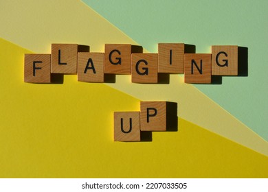 Flagging Up, words in wooden alphabet letters isolated on yellow and green background. Business jargon meaning to bring attention to something - Shutterstock ID 2207033505