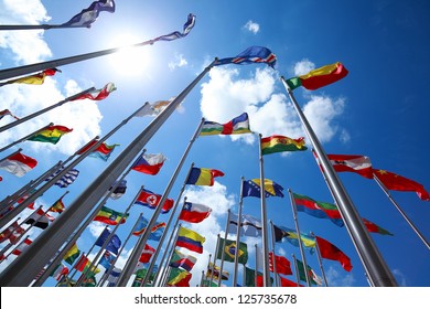 Flags of all nations of the world are flying in blue sunny sky