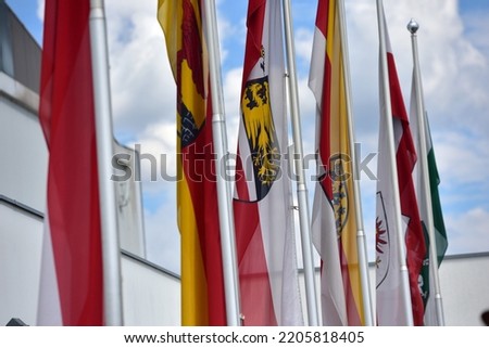Flags of the Austrian federal states in front of a fair hall