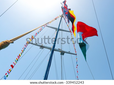 Flags of different countries on the mast of sailboat