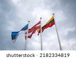 Flags of the Estonia, Latvia and Lithuania, low angle view. Flags of the Baltic States waving on the stormy sky background.