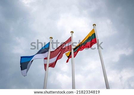Flags of the Estonia, Latvia and Lithuania, low angle view. Flags of the Baltic States waving on the stormy sky background.