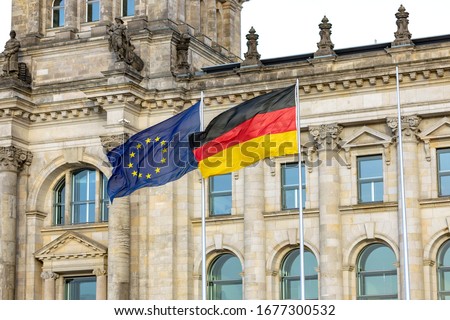 Flags of the European Union and Germany fluttering in the wind against the background of the building