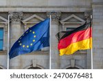 The flags of the European Union and Germany wave in front of the German parliament in Berlin