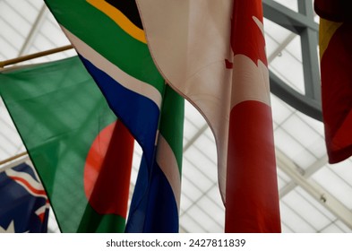 flags of a few different countries taken from a low angle (canada, south africa, bangladesh, australia)