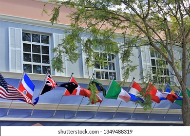 Flags Flying In Front of Building With Three Windows