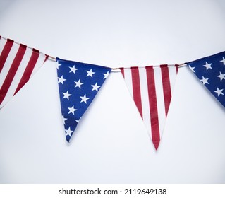Flags in the form of the American flag on a light background. Flags hung in the house on holidays. US flag