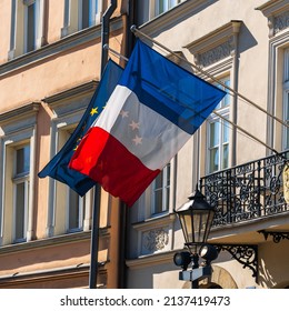 The flags of France and the European Union flutter in the wind on the old wall of the French consulate in a European city on a sunny day - Shutterstock ID 2137419473