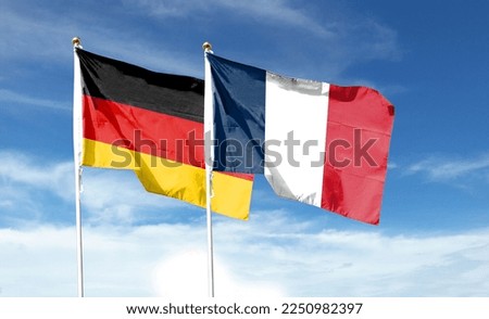 Flags of France flag and Germany flag against cloudy sky. waving in the sky