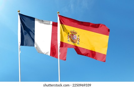 Flags of France flag and Spain flag against cloudy sky. waving in the sky - Shutterstock ID 2250969339