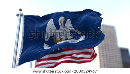 The flags of the Louisiana state and United States of America waving in the wind. Democracy and independence. American state.