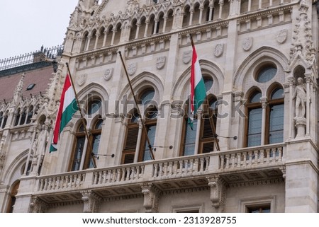 Flags on the beautiful old building of the Hungarian Parliament in neo-Gothic style in Budapest