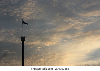 flags over a cloudy sky at sunset.
