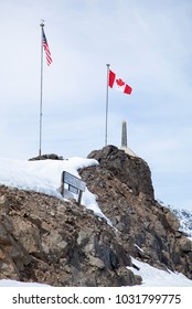 Flags and a pole marking the border line between The United States and Canada in White Pass 2888 feet (880 meters) above sea level (Alaska).