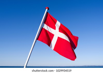 Flags / Seafaring / Denmark: The Danish national flag Dannebrog is fluttering in the wind at the stern of a small ferryboat crossing the Kattegat Sea
