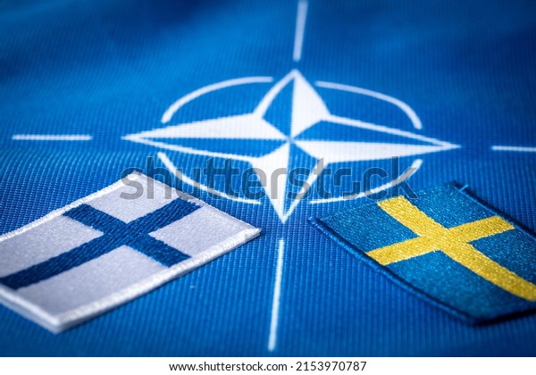Flags\
of Sweden and Finland against the background of the symbol of NATO,\
the Defense Organization, The concept of extending the borders of\
the alliance new Scandinavian countries, 9 May\
2022