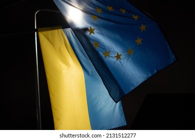 Flags of Ukraine and European Union waving together symbolising accession negotiations. Concept of Ukraine joining EU. - Shutterstock ID 2131512277