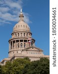 flags unfurled in the wind in front of the Texas State Capitol dome