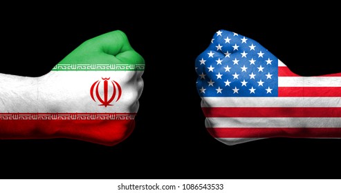 Flags of USA and Iran painted on two clenched fists facing each other on black background/Tensed relationship between USA and Iran concept