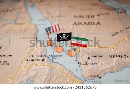 Flags of the USA and Iran surrounding a pirate insignia onto a map of the Red Sea region. It symbolically represents the intricate geopolitical dynamics and potential conflicts in this strategic
