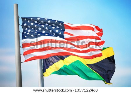 Flags of the USA and Jamaica against the background of the blue sky