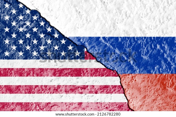 the\
flags of the USA and Russia painted on a ruined wall and divided by\
a diagonal crack. International diplomatic\
relations.
