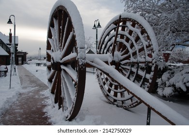 FLAGSTAFF, ARIZONA - DECEMBER 20, 2013: Massive Wooden Wagon Wheels Are Covered In Snow, At Flagstaff Amtrak Station.