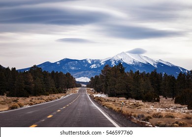 Flagstaff Arizona With Lenticular Clouds Over The Snow Covered San Francisco Peak. Scenic Road Trip During The Winter, USA.