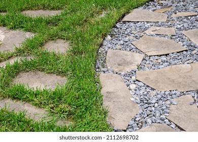 Flagstones On Gravel And Lawn. Combination Of Different Materials In Landscaping.