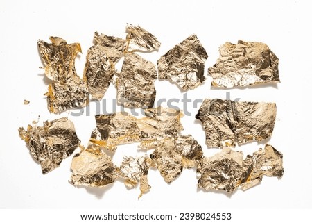 Flakes sheets of gold foil, flat lay. Golden foil pieces of gold sweat or gold leaf, potal