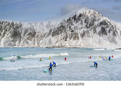 FLAKSTAD BEACH, LOFOTEN ARCHIPELAGO, 26 MARCH, 2019: Young Men Surfing In Arctic Conditions At Flakstag Beach, Lofoten, Norway, Europe