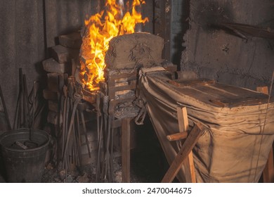 Flame in a forge with hand-made bellows in an old rural workshop. Traditional crafts