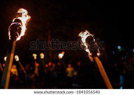 Flame on a homemade torch, fire on the background of night streets, peaceful actions with torches.