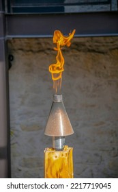 Flame On A Torch Kit On A Wood In San Antonio, Texas. Selective Foocus Close-up Of A Fire Flame On A Torch Against The Blurred Wall Background.