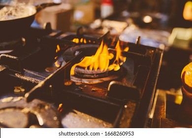 Flame In The Pan. Professional Chef Makes Flambe For Food In The Restaurant Kitchen. Chef Cooking With Open Fire Pan. On A Stove. Fire Burn Is Cooking On Iron Pan. Vintage Photo Processing