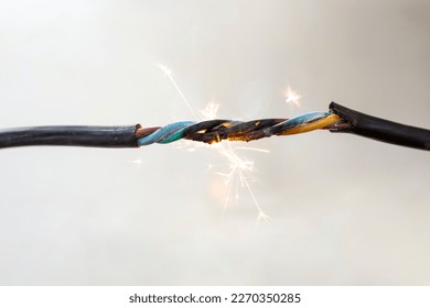 flame smoke and sparks on an electrical cable, fire hazard concept, soft focus close up
