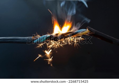flame smoke and sparks on an electrical cable, fire hazard concept, soft focus close up