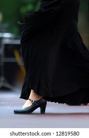 Flamenco Dancer In The Movement. Black Skirt And Black Shoes. Focus On Shoe. Background Out Of Focus.